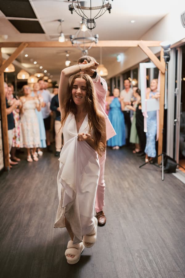 The bride Olivia dances with the groom Jake at the reception stage of White Horse Ranch, surrounded by applauding guests.