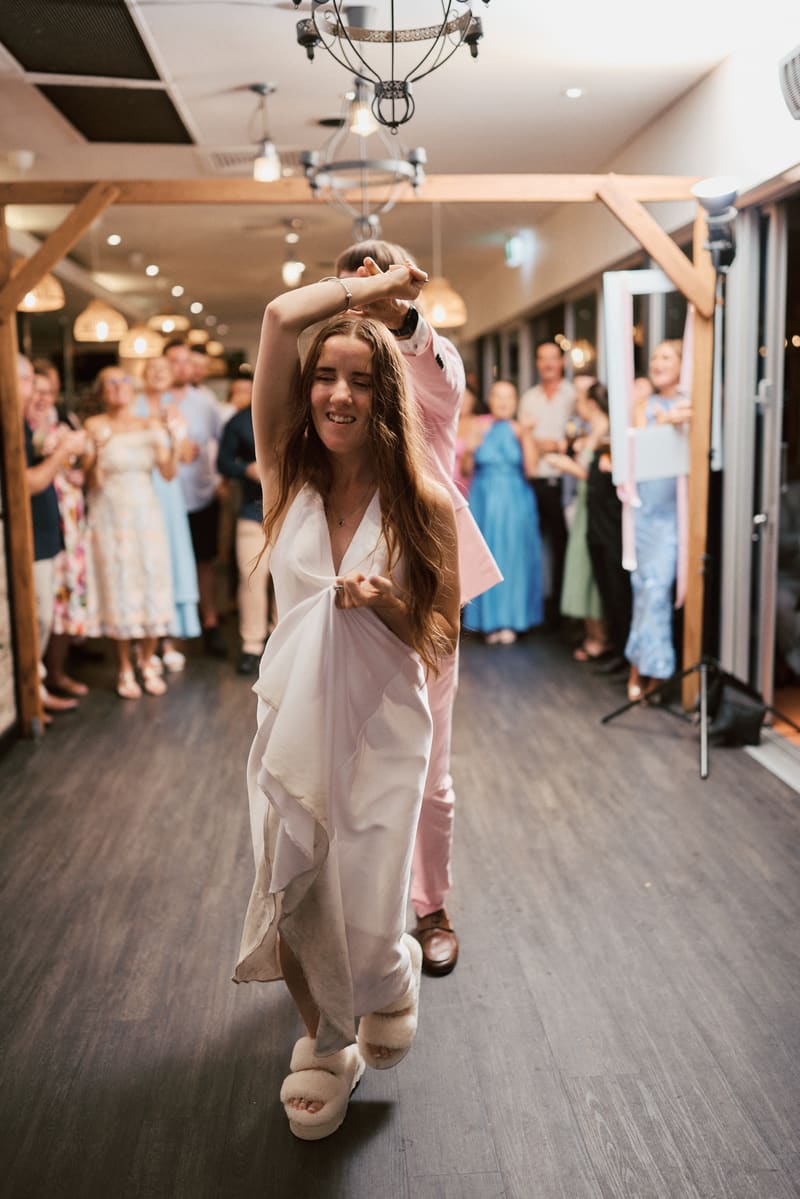 The bride Olivia dances with the groom Jake at the reception stage of White Horse Ranch, surrounded by applauding guests. Spring engagement session Brisbane by She Said Yes.