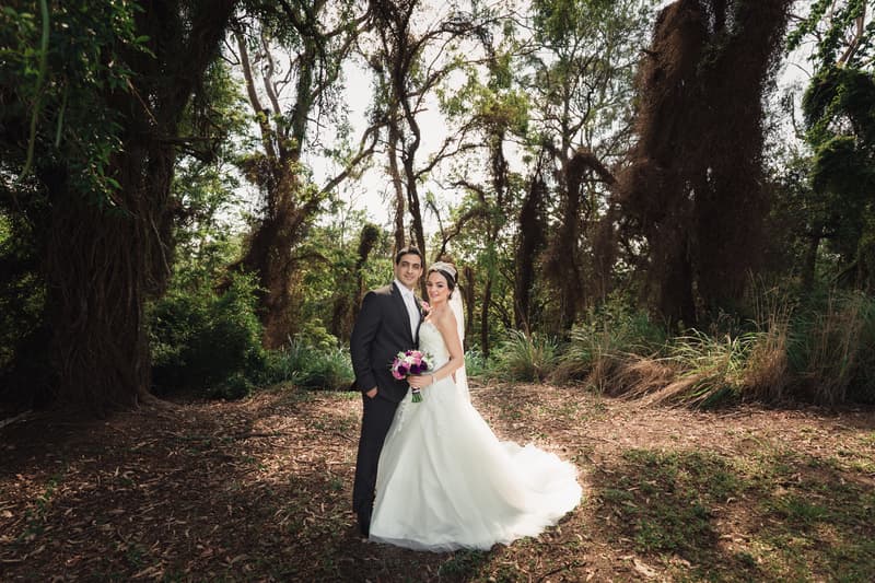 Pasha and Maryam pose together outdoors in a wooded area for couple portraits after their ceremony.