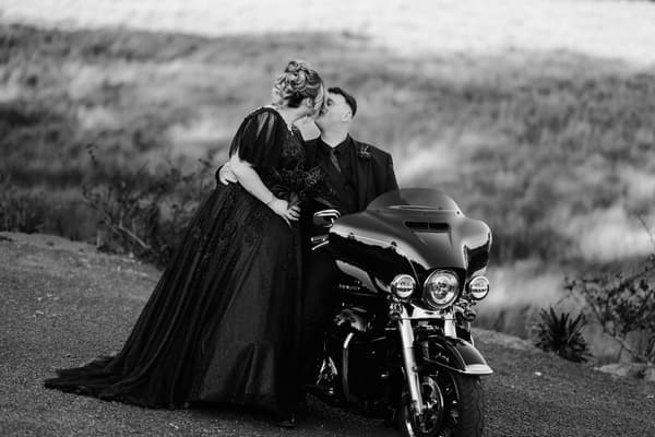 Renae and Adam share a kiss beside a motorcycle at Ocean View Estates during their couple portraits session.