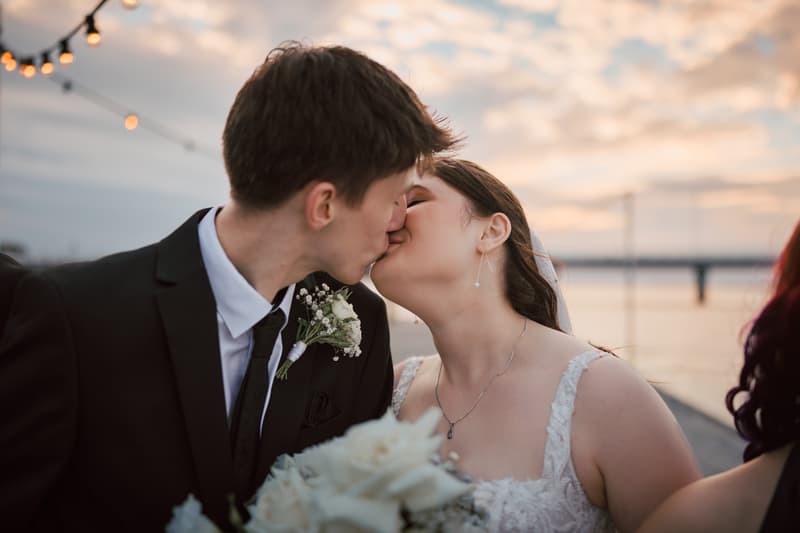 Terion the bride and Tyler the groom share a kiss during their couple portraits session at Sandstone Point Hotel.