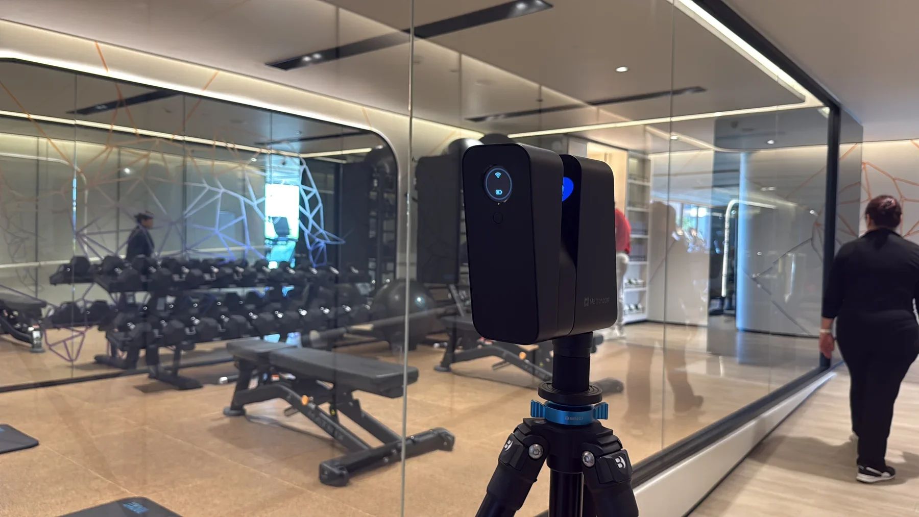 Matterport camera on a tripod capturing the gym at Chiang Mai Marriott Hotel, beside mirrors and free weights.