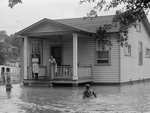 Children on porch of house surrounded by flood - Art Print