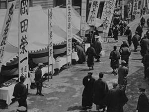 Election Day in Tokyo Japan shows a line of tables with signs in Kanji advertising political candidates - Art Print