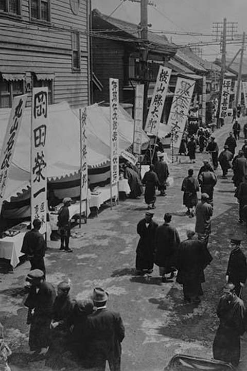 Election Day in Tokyo Japan shows a line of tables with signs in Kanji advertising political candidates - Art Print