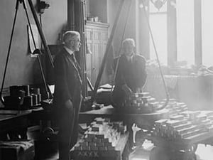 Two suited men weigh bars of gold on scales at the US Mint - Art Print