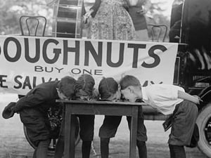 Boys Chow Down on a Table in a Donut Eating Contest - Art Print