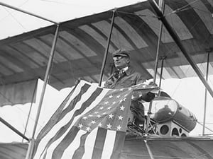 Aviator C.B. Harmon Unfurls Stars and Stripes from his pilot seat on his Biplane. - Art Print