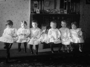 Seven Toddlers in white Dresses seated on Bench - Art Print