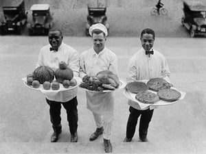 Three Chefs stand on bottom of a line of steps and hold up Thanksgiving platters of Pies