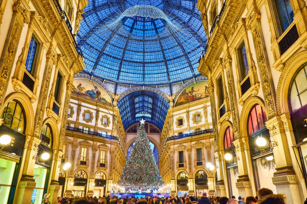 Galleria Vittorio Emanuele II illuminated by christmas lights and a shinny christmas tree. Milan, Lombardy, Italy