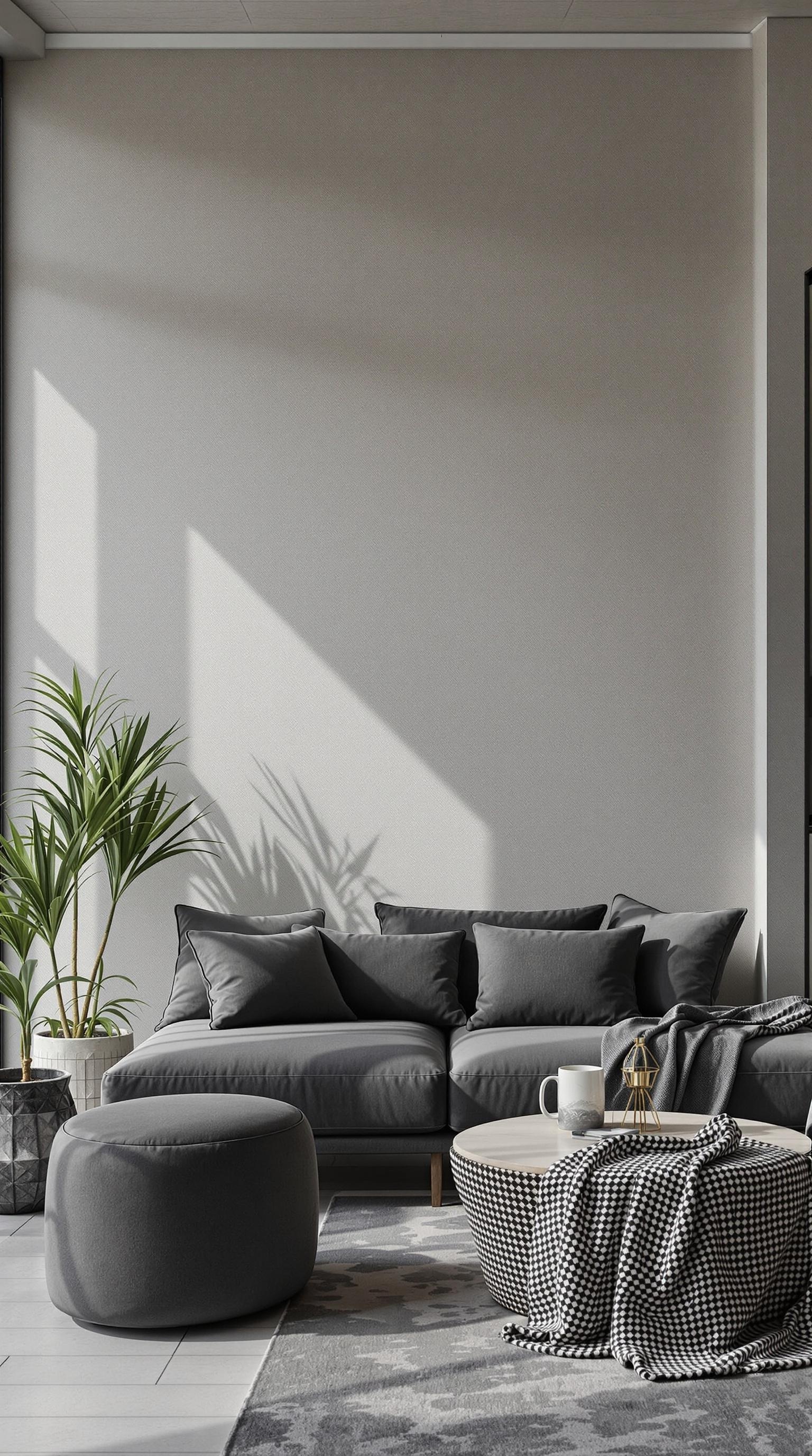 Cozy living room featuring a charcoal gray sofa, pillows, and a round ottoman, with a plant and wooden coffee table.