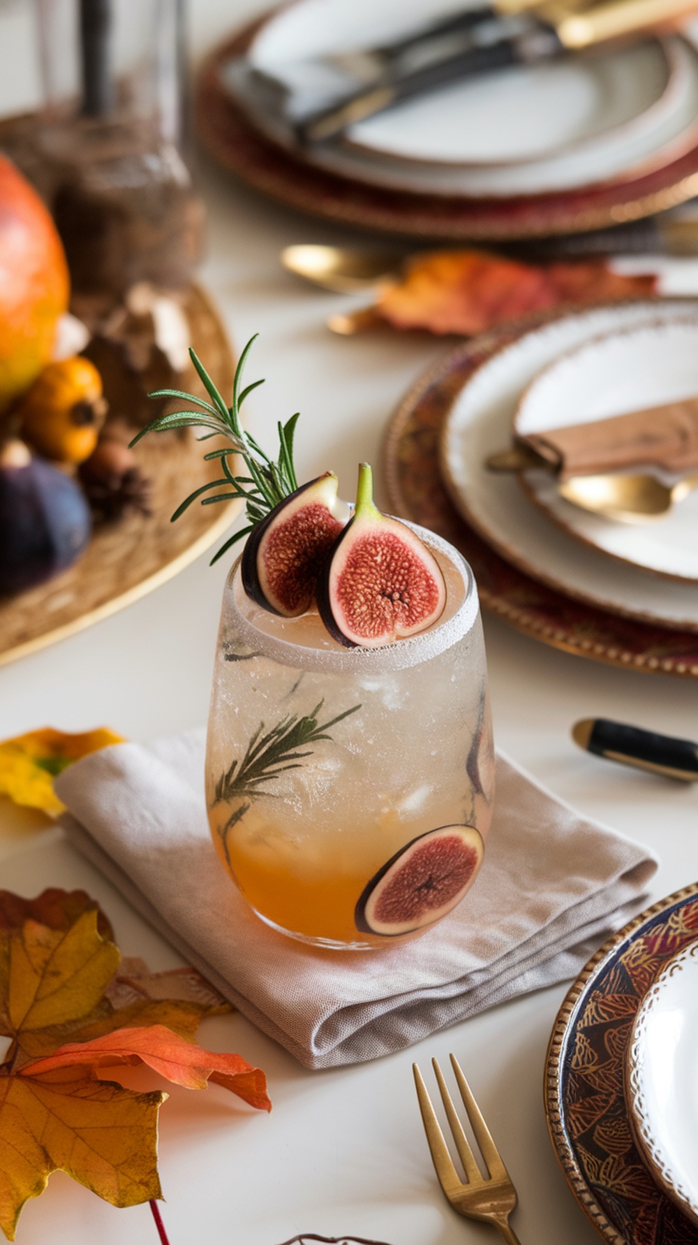 A sparkling fig mocktail garnished with fresh figs and rosemary, set on a beautifully arranged Thanksgiving table.