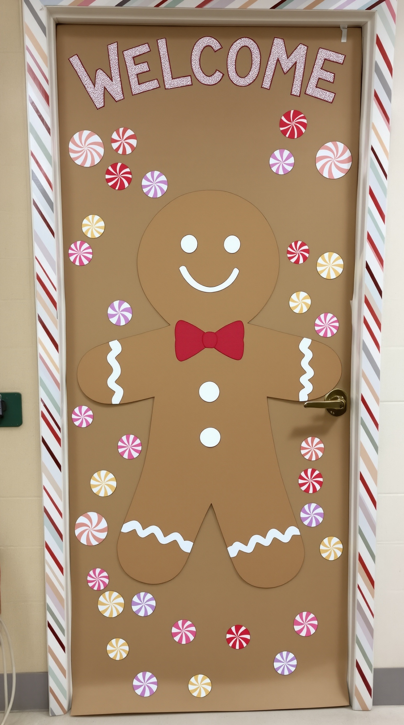 A classroom door decorated as a gingerbread man with candy accents and a 'WELCOME' sign.