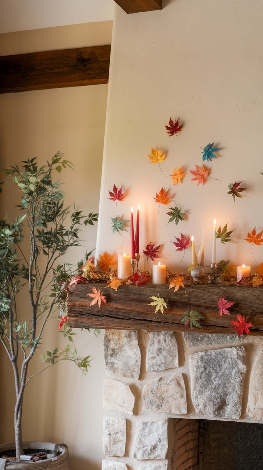 A decorated mantel with colorful leaves, candles, and a rustic wooden beam.