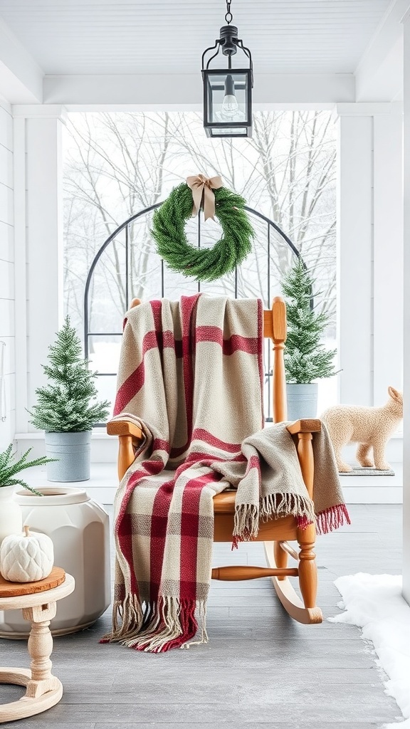 A cozy winter porch with a plaid blanket on a rocking chair, surrounded by potted trees and a decorative wreath.