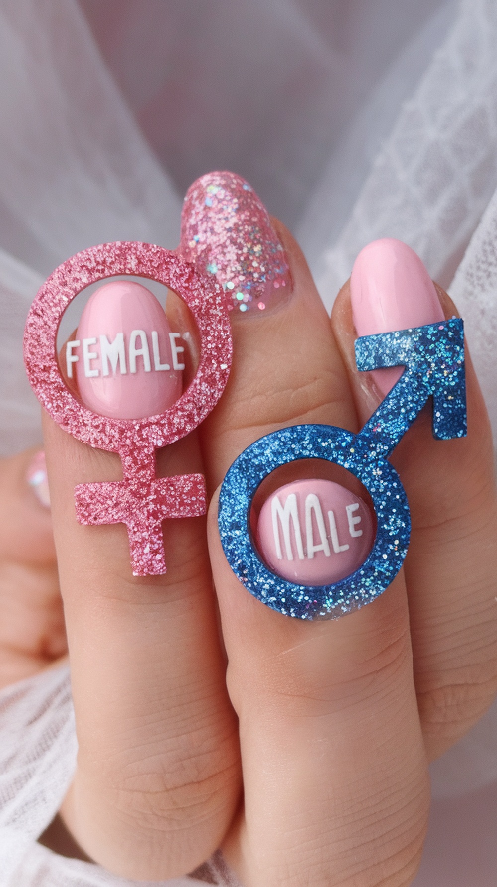 Nails featuring glittery gender symbols for gender reveal party