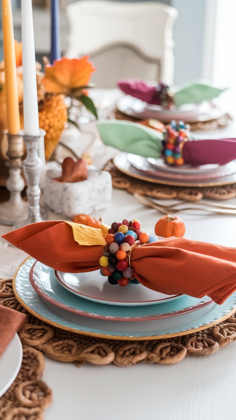Colorful kid-made napkin rings made of pom-poms on a Thanksgiving table setting.