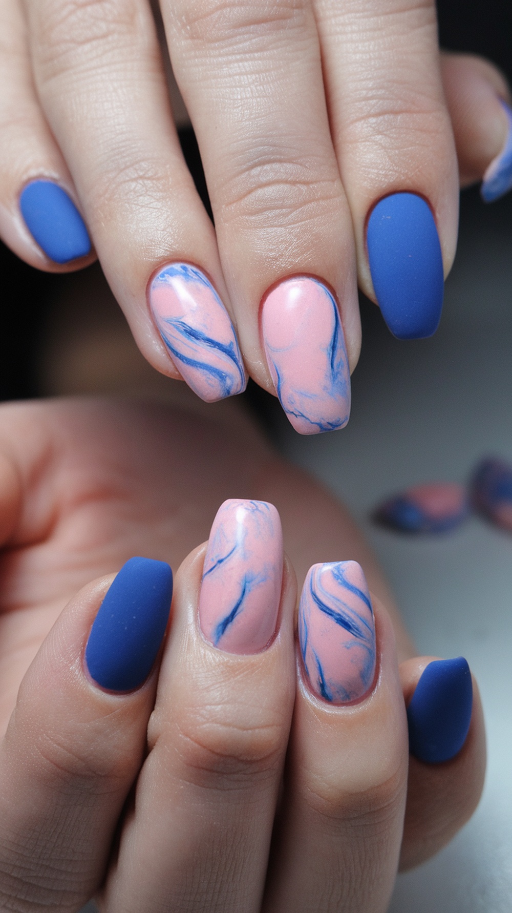 Nails featuring a marble effect with pink and blue colors, perfect for a gender reveal.