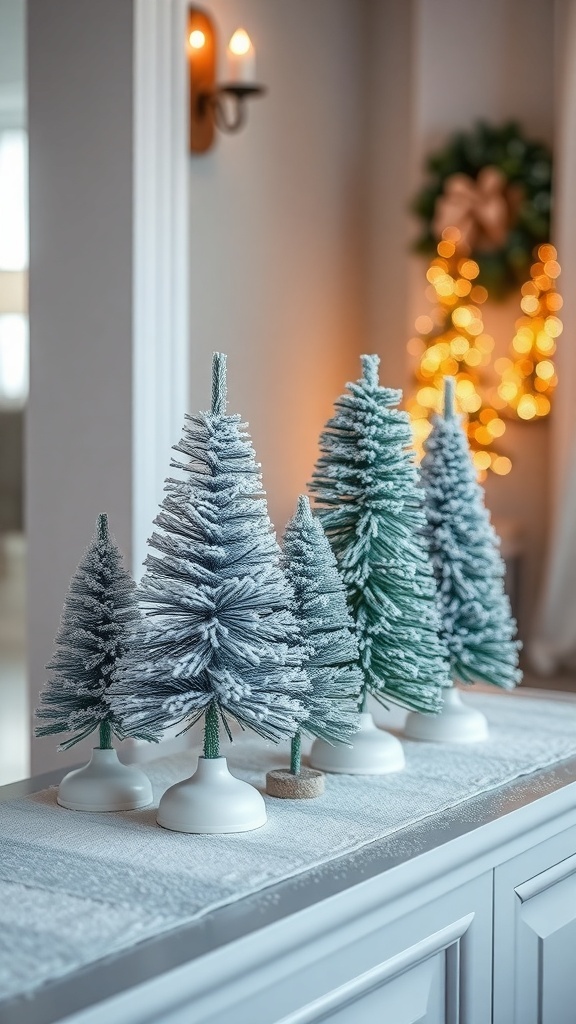 A collection of snow-dusted miniature Christmas trees on a white table, with soft lighting in the background.