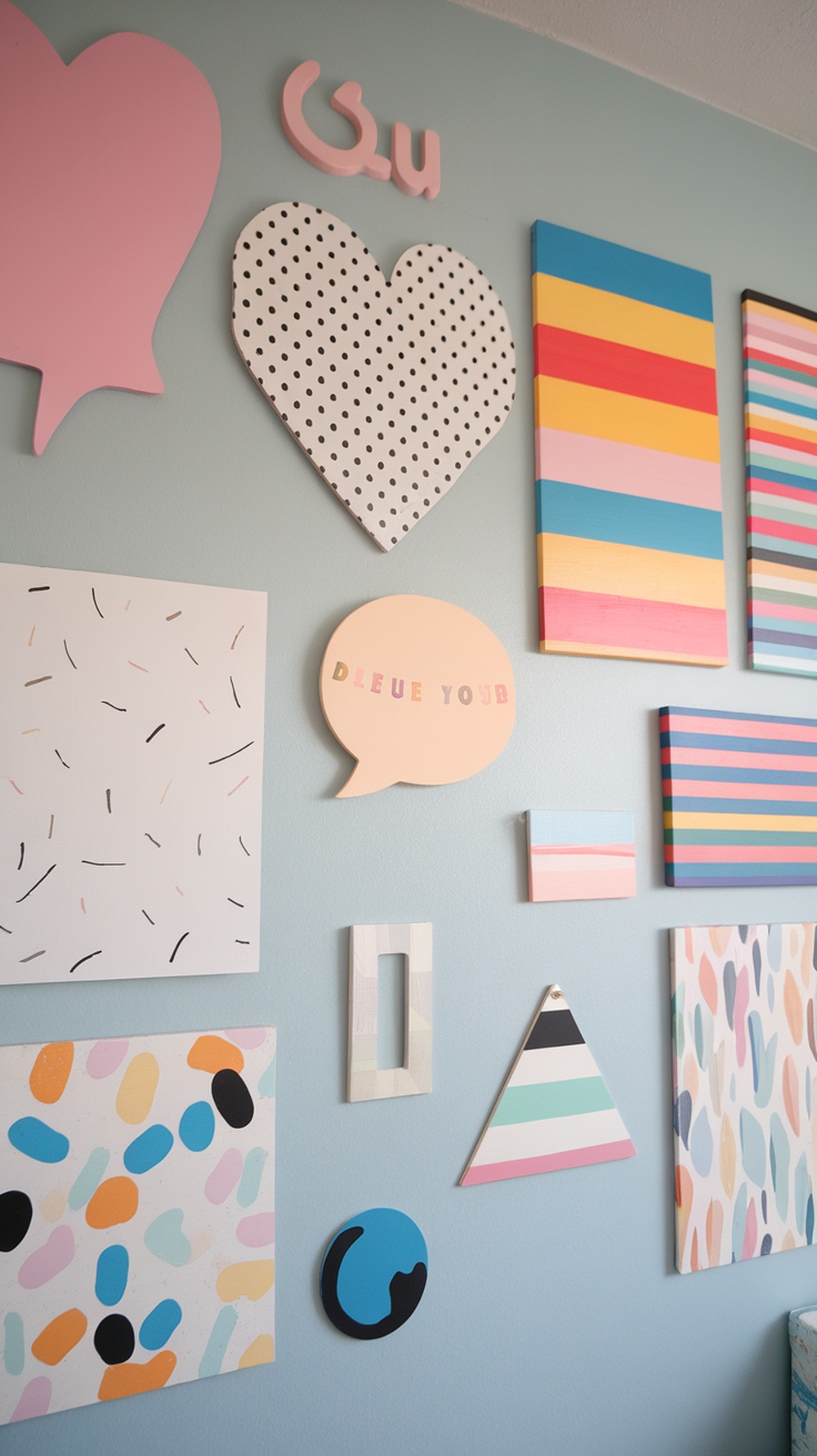 A colorful wall art display featuring various shapes and patterns in a dorm room.