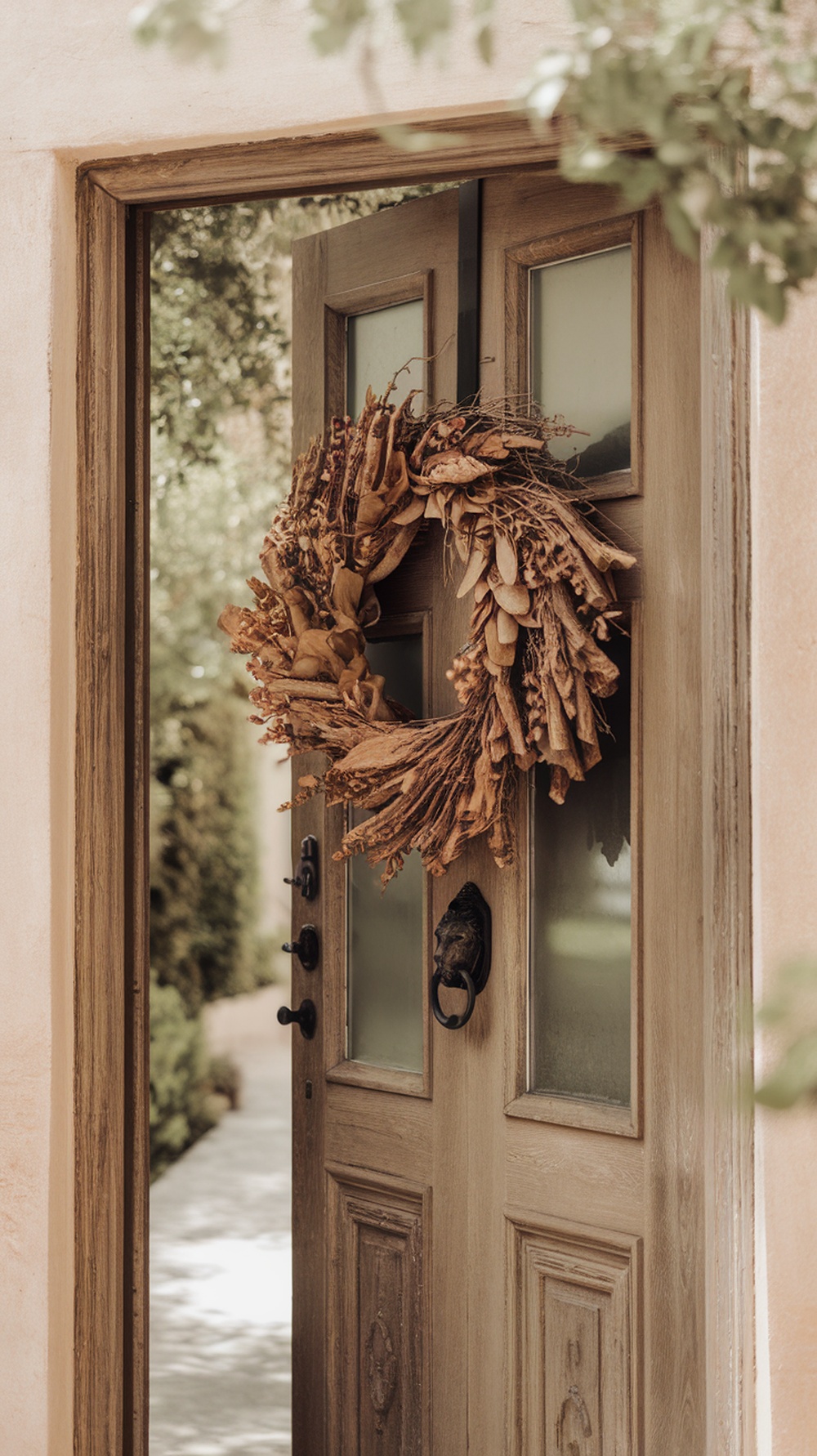 A rustic wreath made of dried leaves hanging on a wooden door.