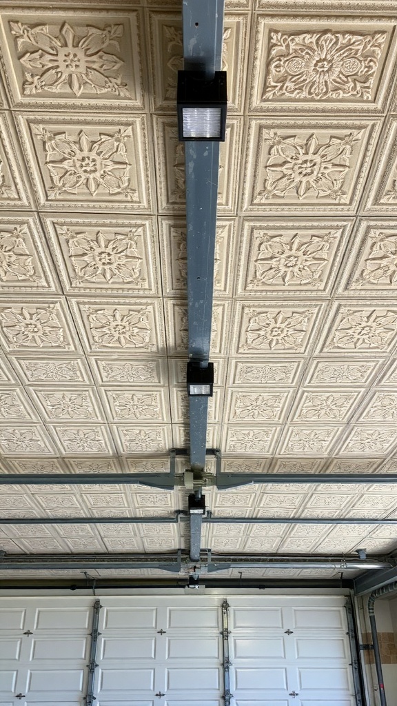 Decorative ceiling tiles in a garage with overhead lights