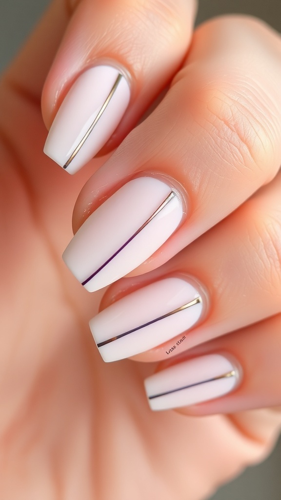 Nails with a white base and delicate metallic line accents