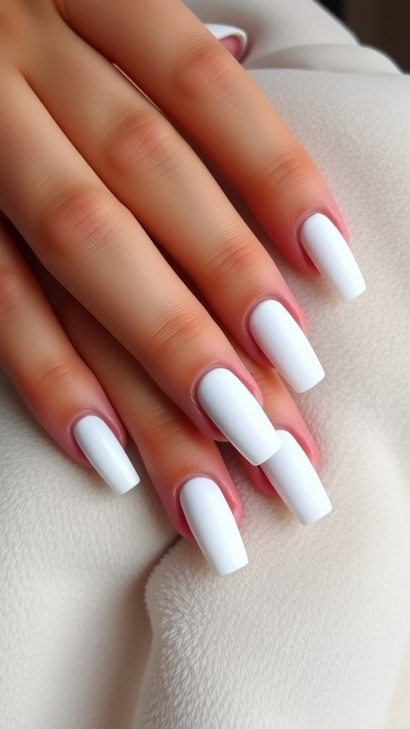 Close-up of hands with matte white French nails resting on a soft, beige fabric.