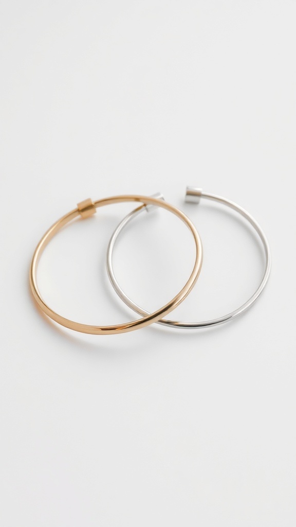 Two minimalist cuff bracelets, one gold and one silver, displayed on a white background.