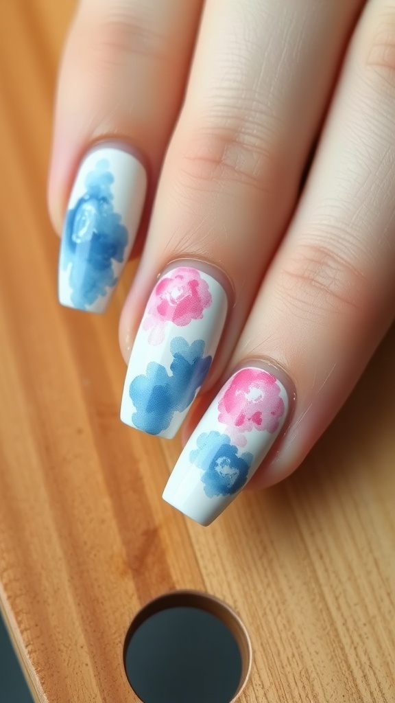 A watercolor nail art design featuring soft pink and blue colors with delicate branches.