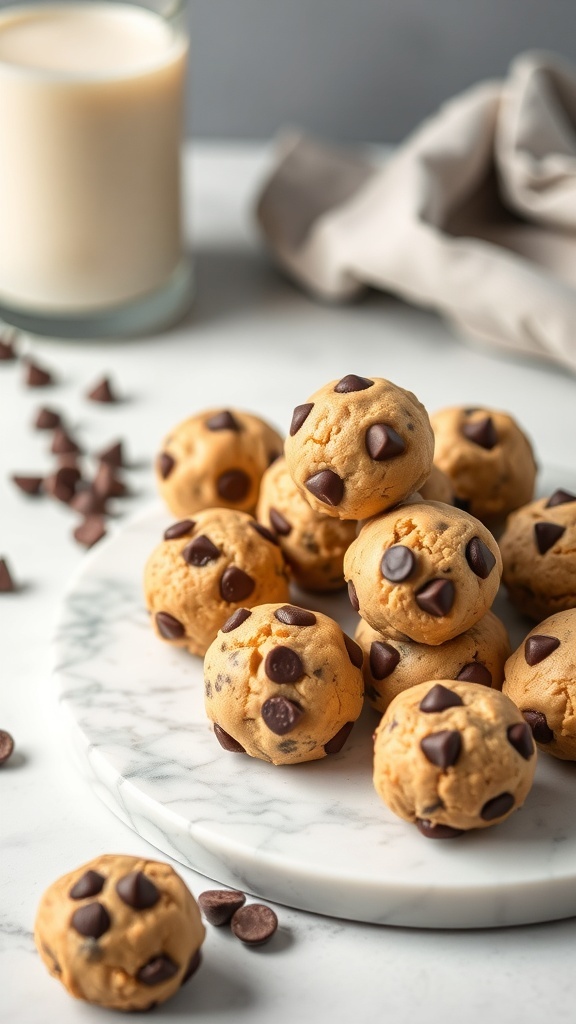 A plate of healthy chocolate chip cookie dough bites with a glass of milk in the background.