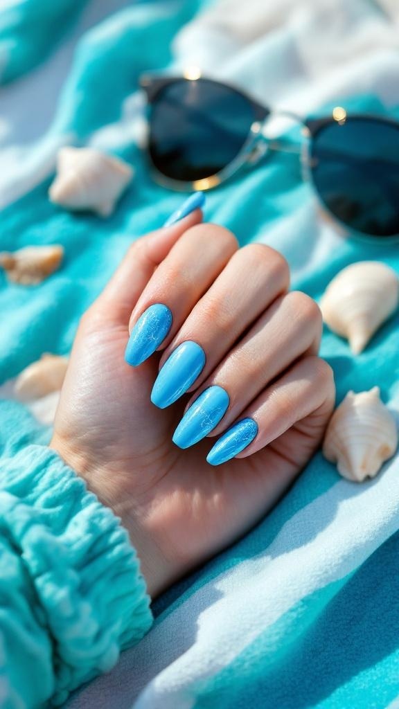 A hand with turquoise nail polish on a striped beach towel, surrounded by seashells and sunglasses.