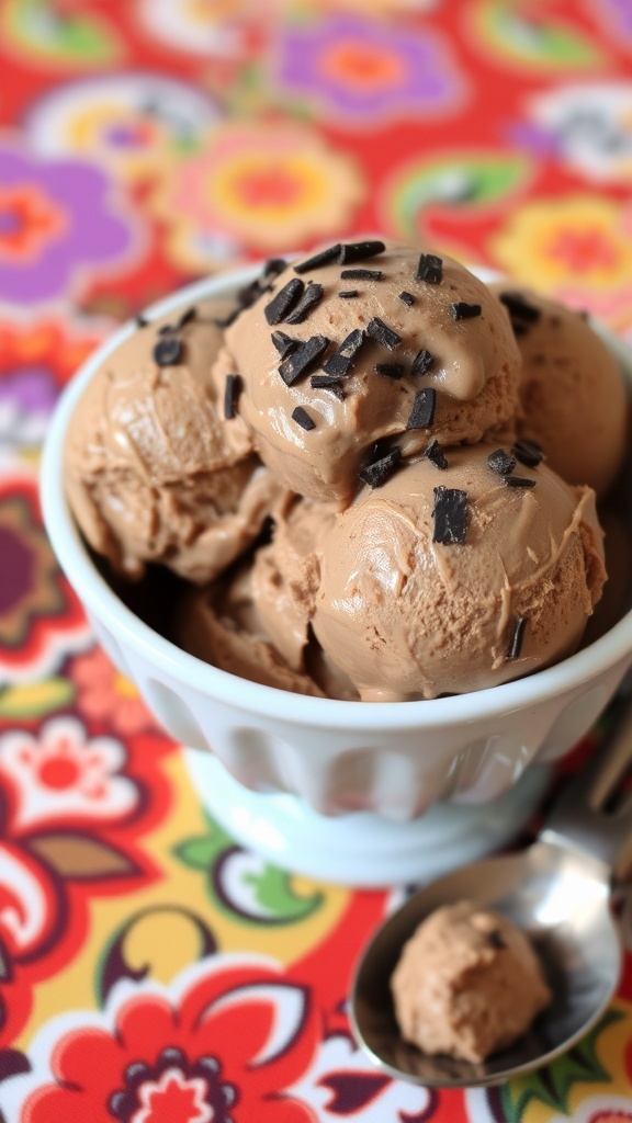 A bowl of low-sugar chocolate ice cream with mint leaves on top, placed on a colorful floral tablecloth.