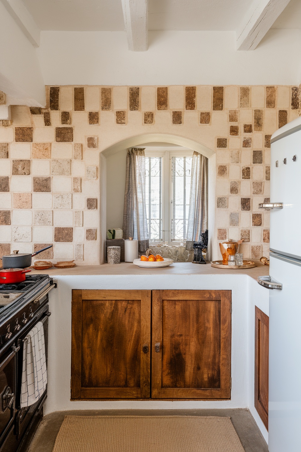 A kitchen with a textured backsplash featuring earthy toned tiles, wooden cabinets, and natural light.