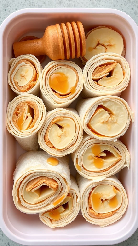 Peanut butter and banana wraps neatly arranged in a lunchbox with honey drizzled on top.