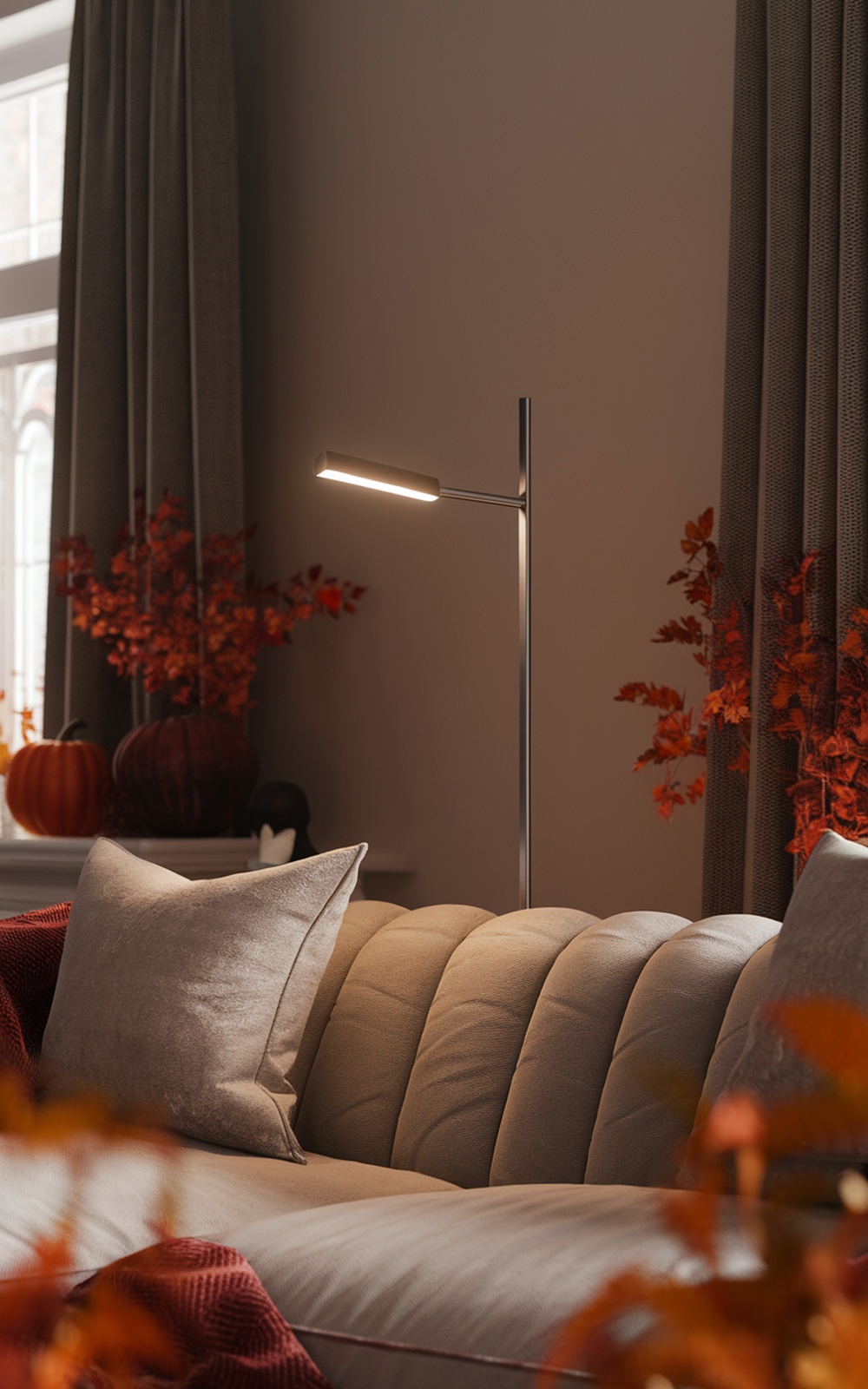 A modern minimalist floor lamp next to a cozy sofa with fall decor.
