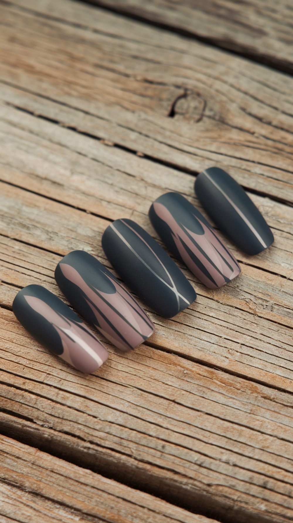 Matte finish nail designs in earthy tones on a wooden surface