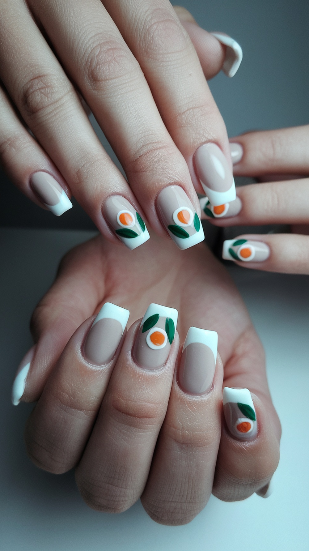 Minimalist fall nail design featuring neutral colors with leaf and fruit accents.
