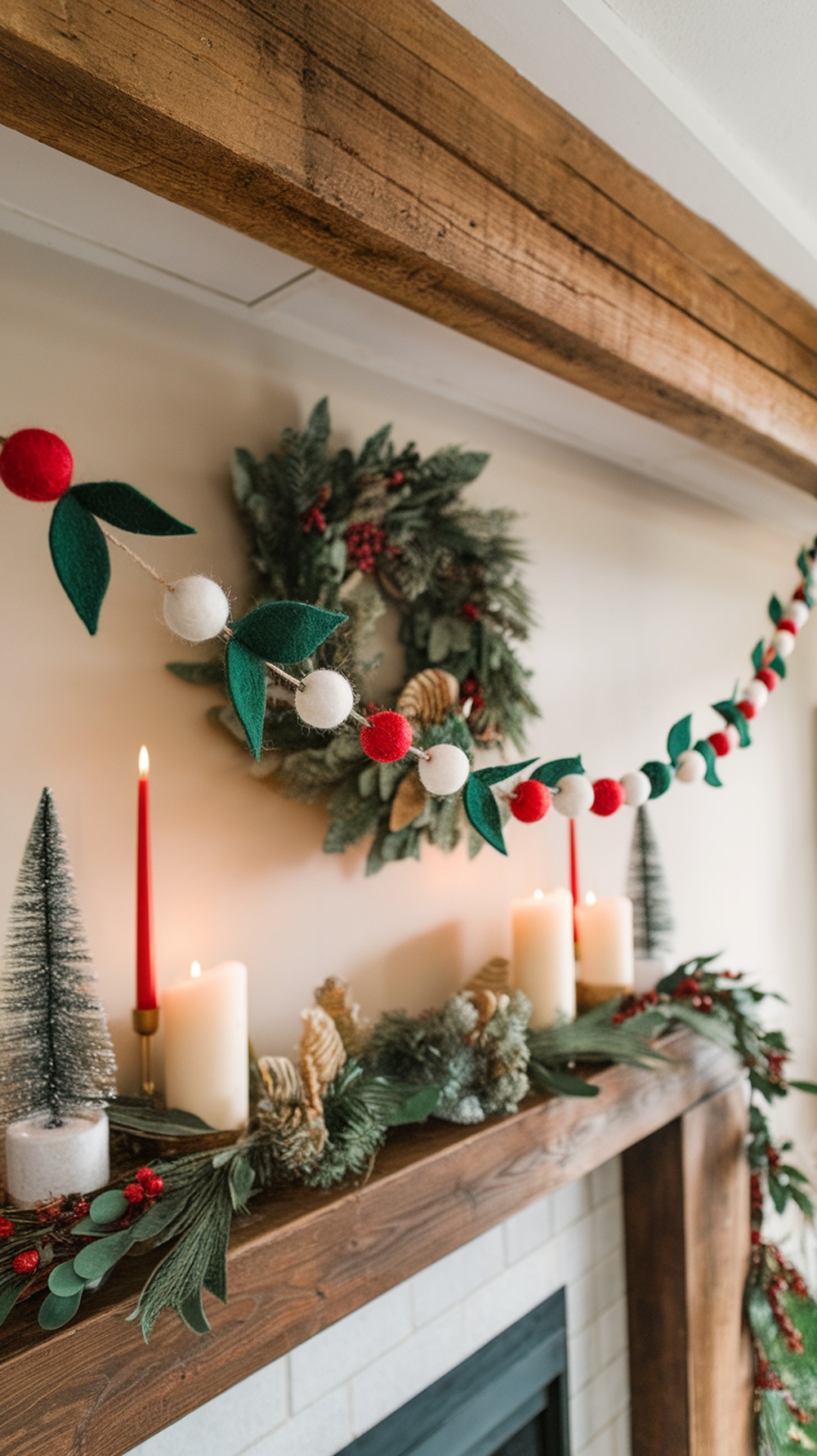 A festive felt garland with red and white balls and green leaves, draped over a mantel decorated for the holidays.