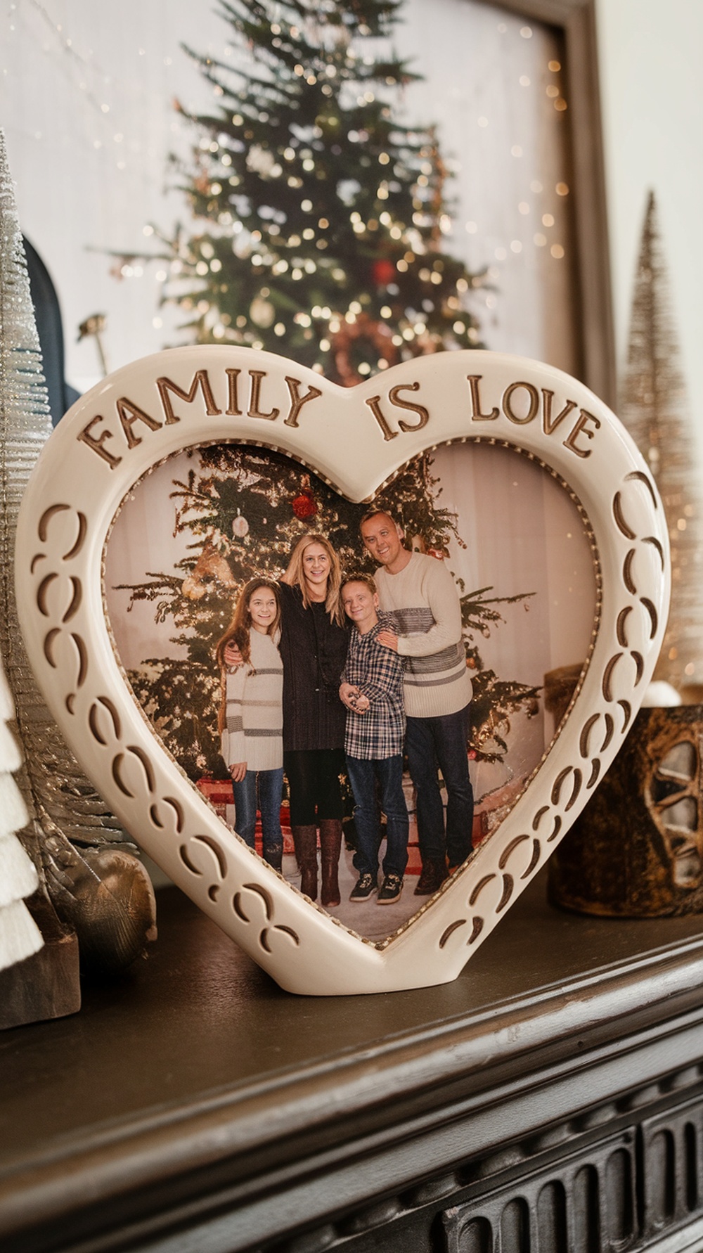 A heart-shaped resin picture frame with the inscription 'FAMILY IS LOVE' holding a family photo.