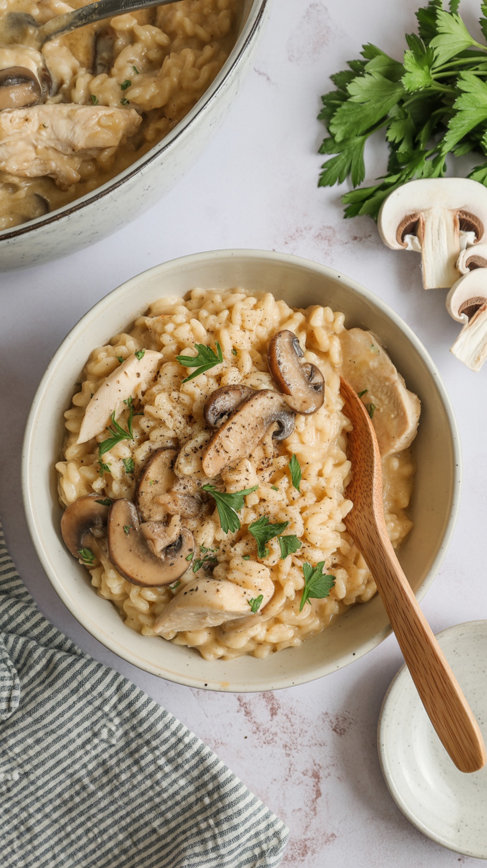 A bowl of creamy chicken and mushroom risotto garnished with parsley.