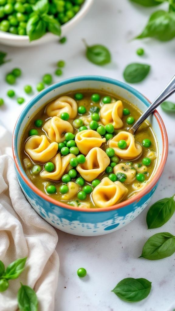 A bowl of vegetarian tortellini soup with peas and basil, garnished with fresh basil leaves.