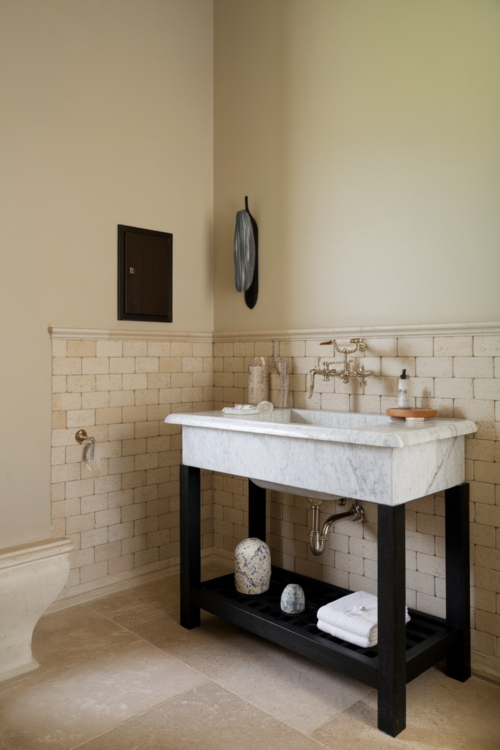 A stylish bathroom featuring a marble sink with elegant fixtures, showcasing a blend of modern and traditional design elements.