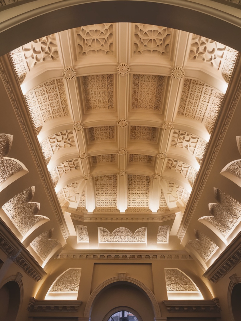 A beautifully detailed ceiling with warm lighting highlighting its architectural features.