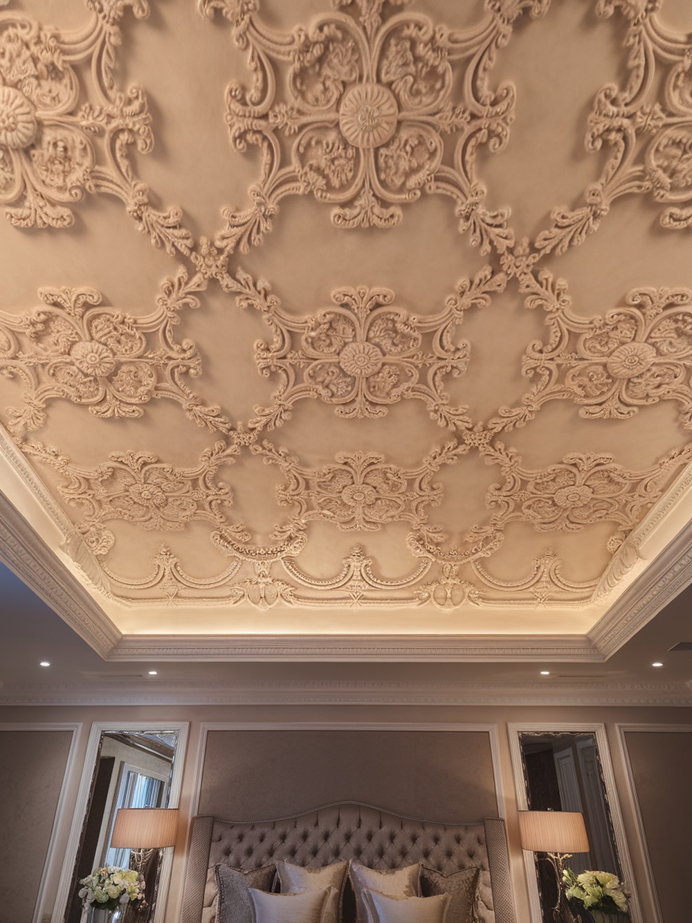 Intricate plasterwork ceiling design in a stylish bedroom