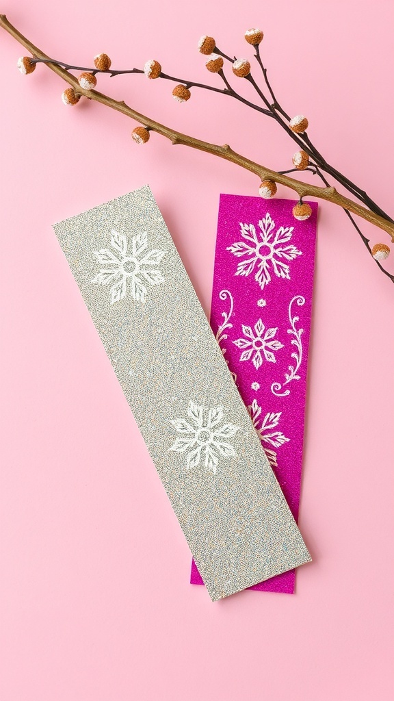 Two metallic foil bookmarks in silver and pink with snowflake designs on a pink background.