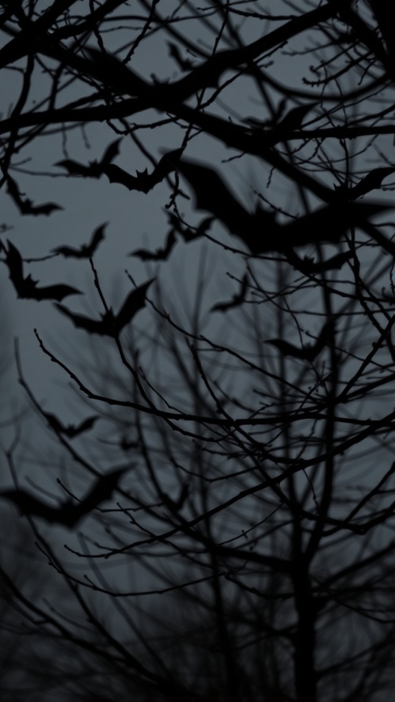 Dark branches with bat cutouts against a gloomy background