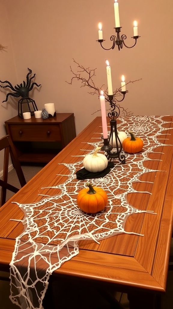 A wooden dining table decorated with a white spiderweb table runner, mini pumpkins, and taper candles.