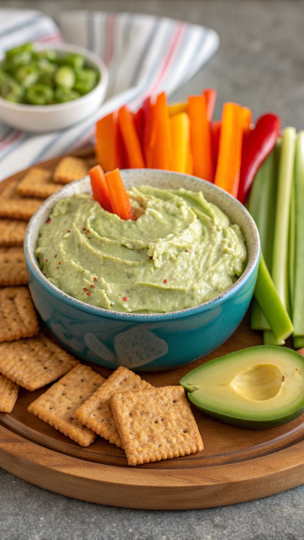 Creamy avocado and cottage cheese dip served with colorful veggies and crackers.